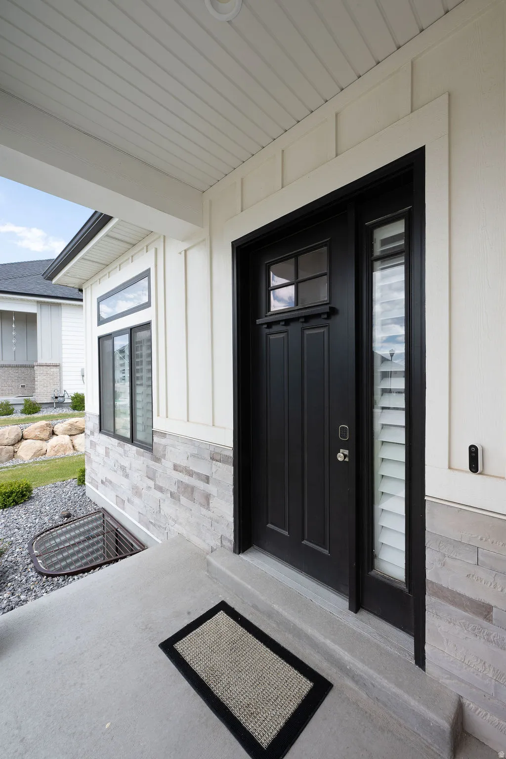 Black paneled entry door with sidelight and transom window