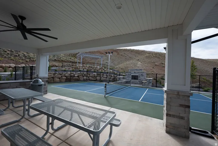 Covered patio area with a slatted ceiling and a large ceiling fan