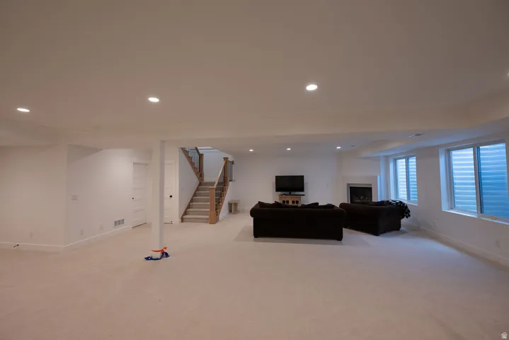 Spacious lower-level living area featuring recessed lighting and plush carpeting