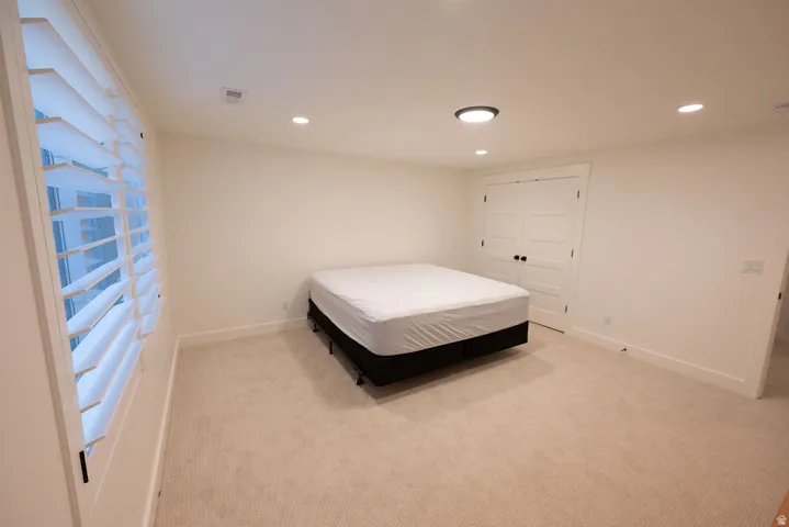 Neutral-toned room with plush carpeting, recessed lighting, and a modern flush-mount ceiling fixture