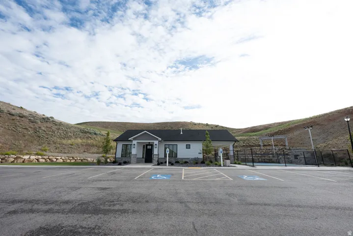 Modern community building featuring light-toned siding, stone veneer accents, and a dark asphalt shingle roof