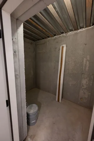 Concrete walls and floor create a durable interior space with exposed metal ceiling joists