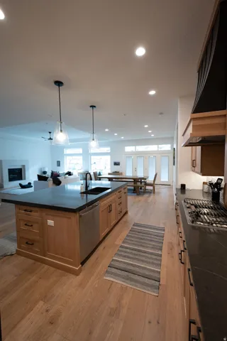 Expansive kitchen island with a dark countertop and integrated sink, complemented by natural wood-finish flooring