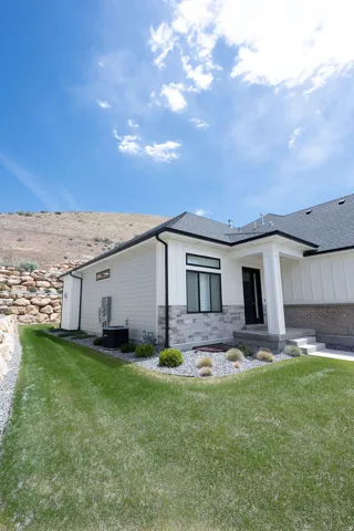 Contemporary exterior featuring white siding and gray stone accents