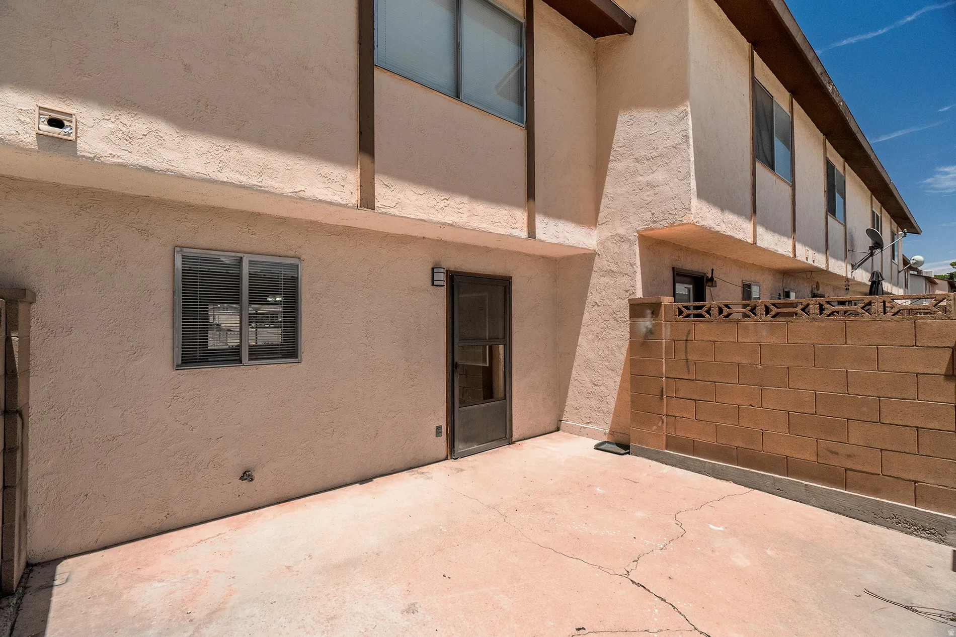 Private concrete patio area enclosed by a block wall
