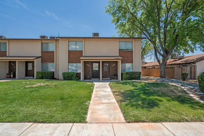 Two-story residential building with stucco and brick facade