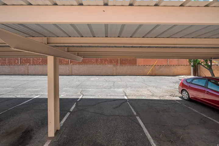 Covered parking structure featuring a corrugated metal roof and robust support beams