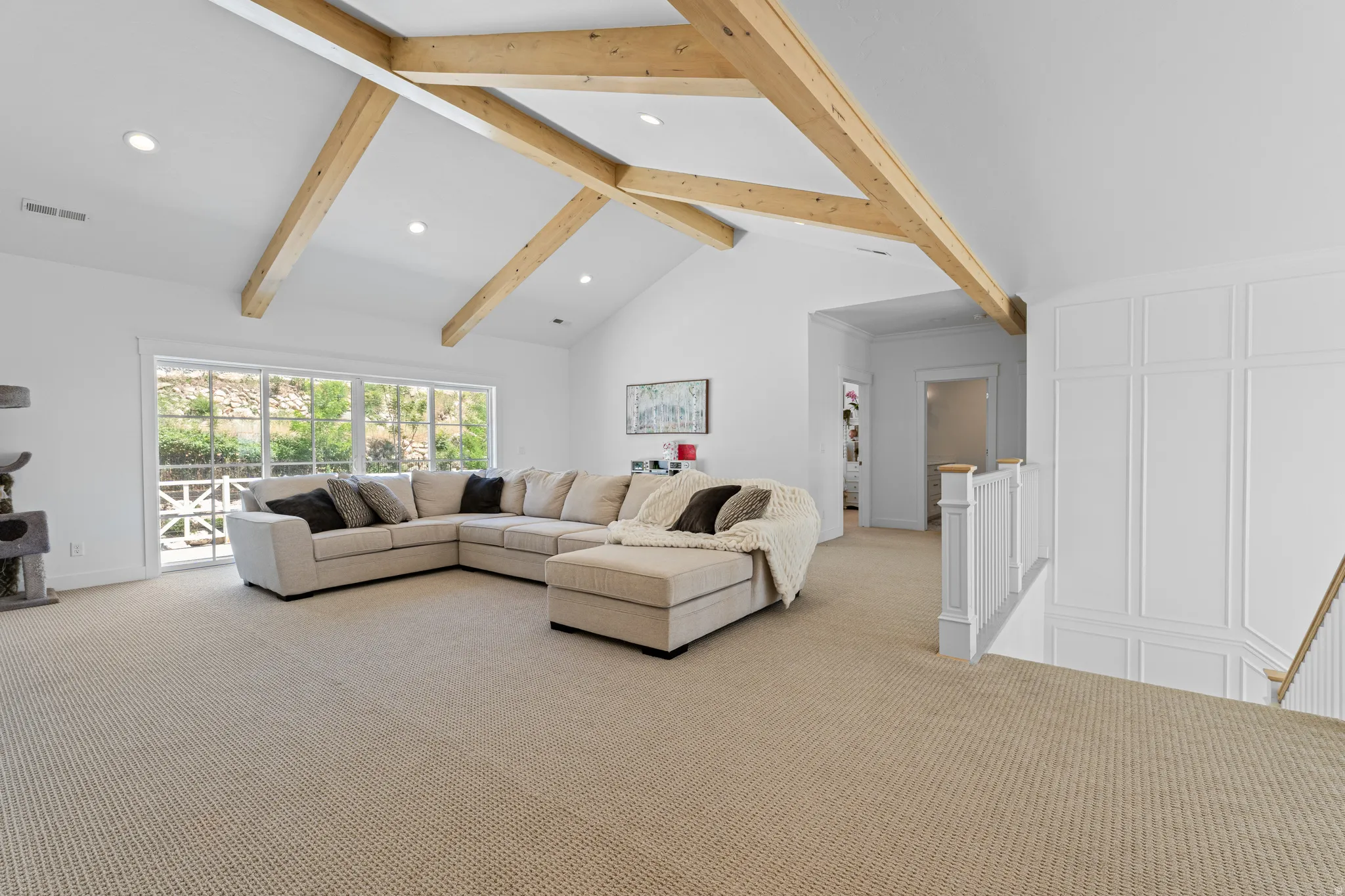 Vaulted ceiling with exposed wood beams, recessed lighting, and wall-to-wall carpeting