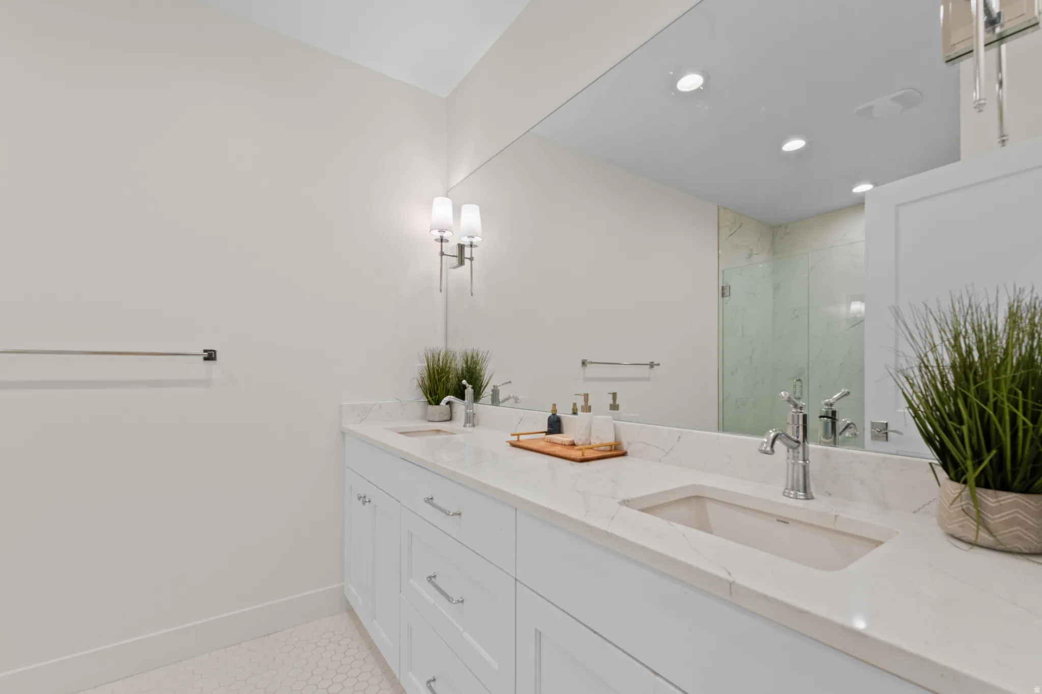 Double vanity with a light-colored countertop, undermount sinks, and chrome fixtures
