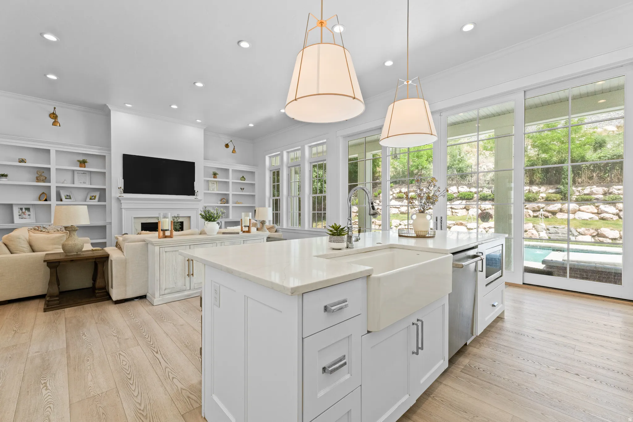 Modern kitchen island featuring a farmhouse sink, integrated dishwasher, and microwave drawer