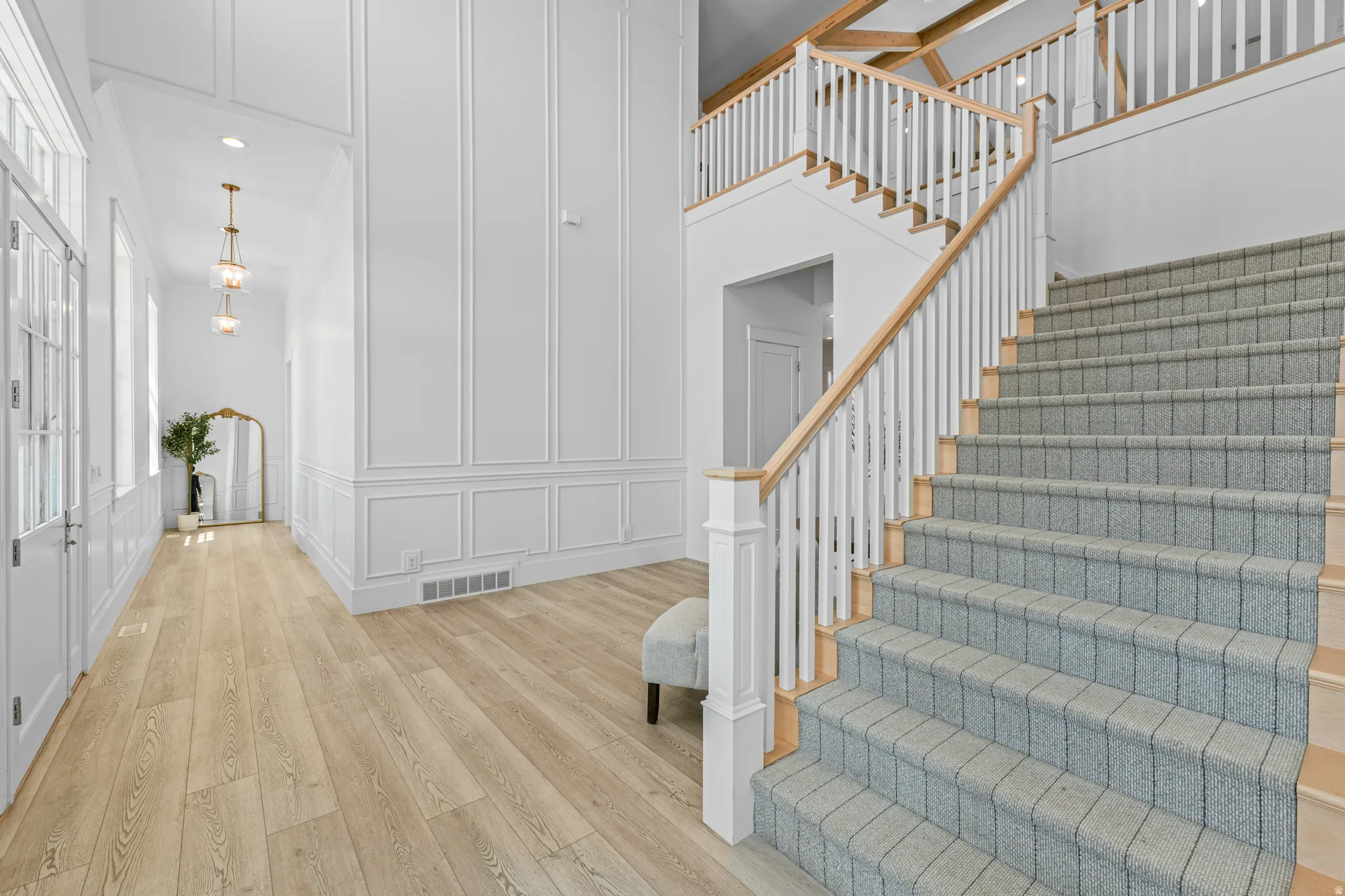 Grand entrance featuring a custom staircase with carpeted treads and a light wood railing