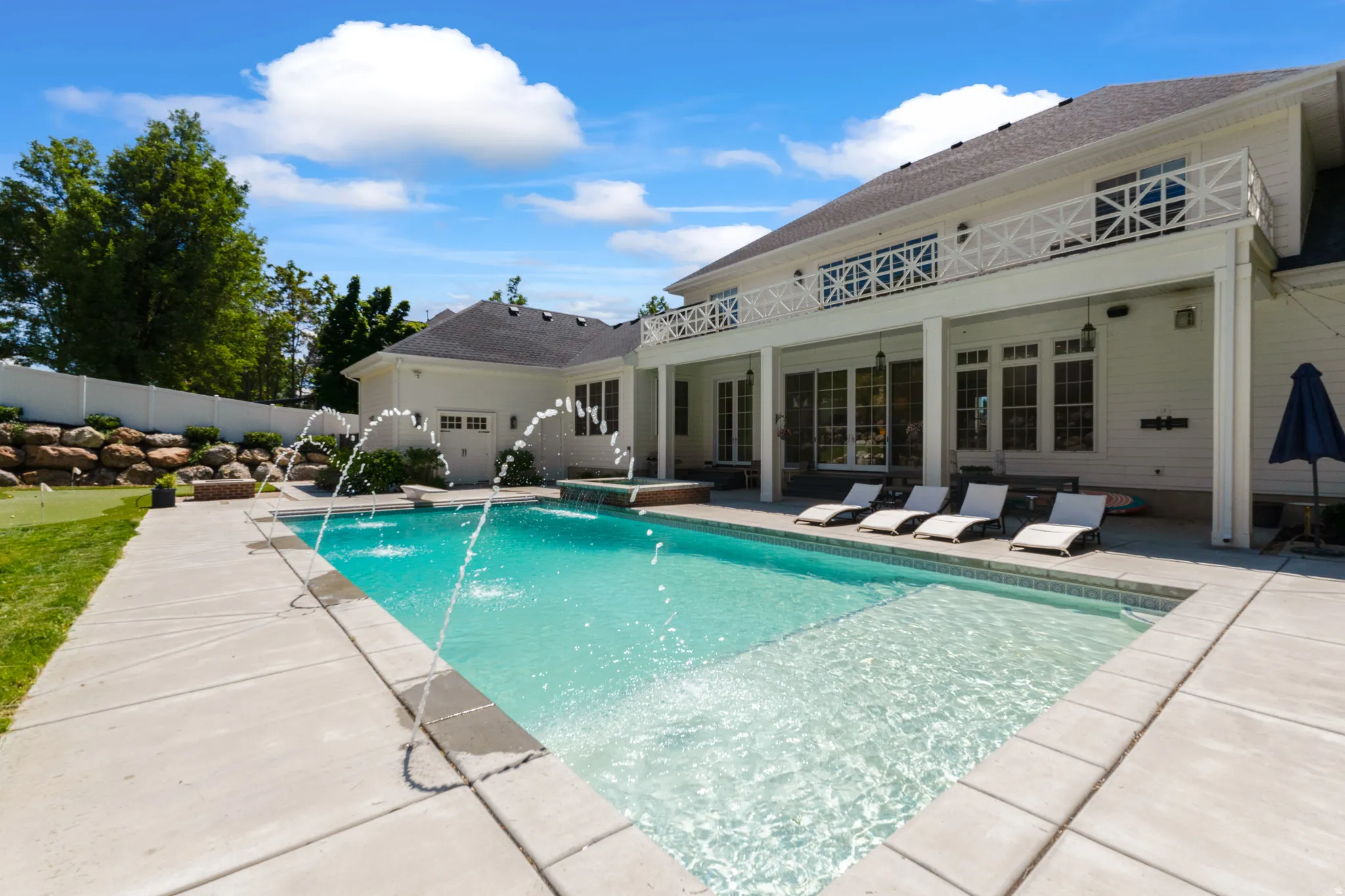 Outdoor swimming pool featuring water jets and a sun shelf
