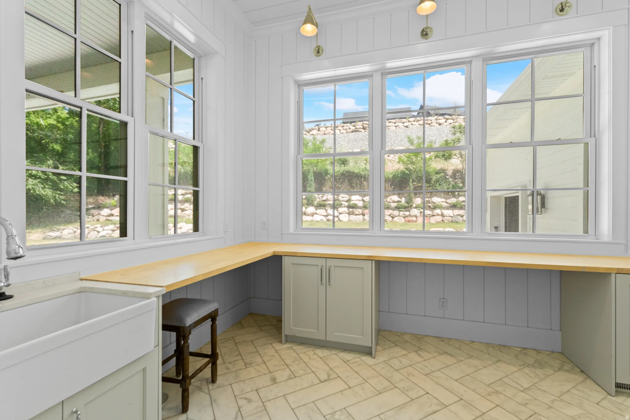 Room with an integrated farmhouse sink and chrome faucet, surrounded by built-in cabinetry