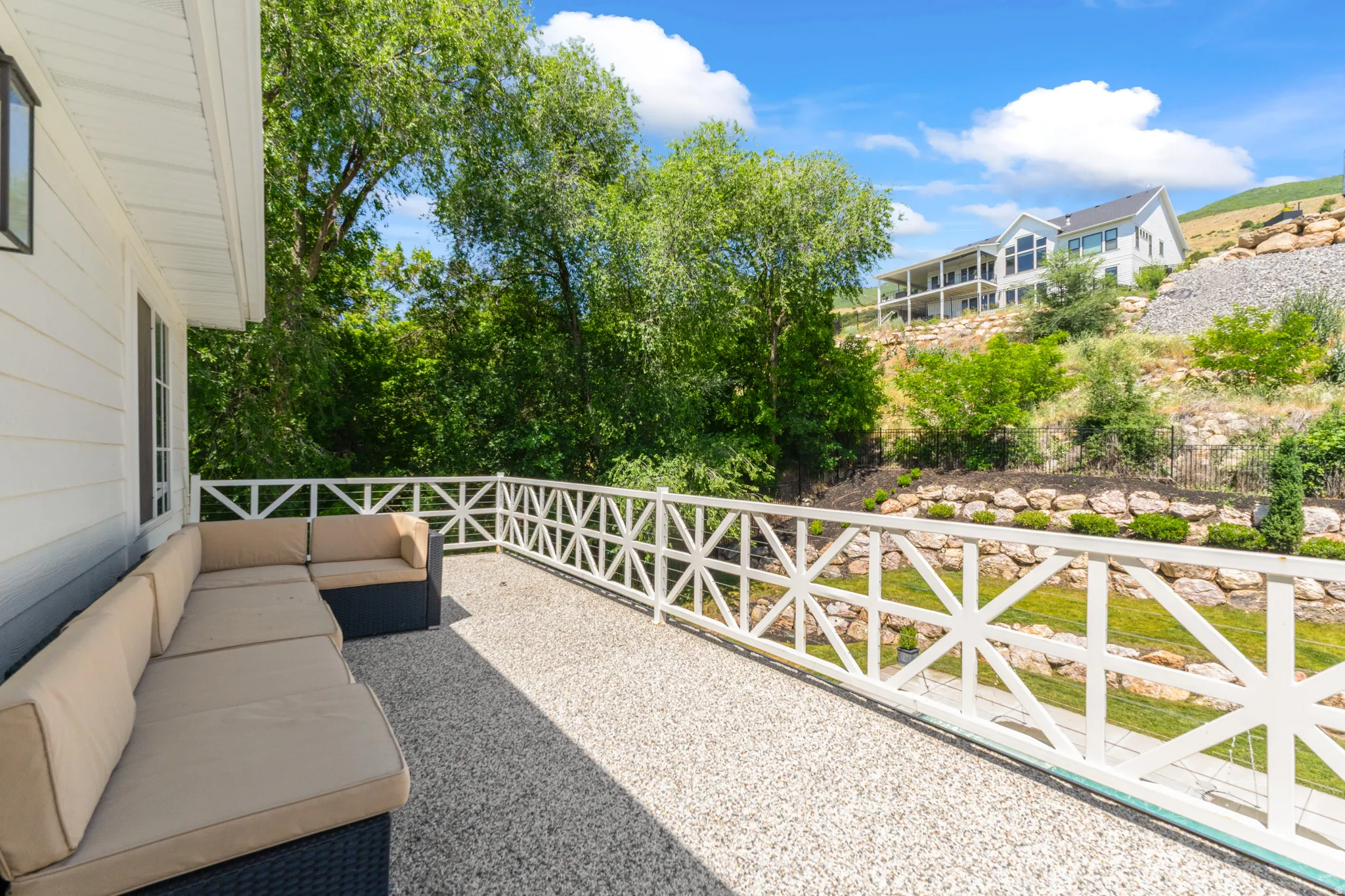 Spacious outdoor patio area featuring a textured aggregate surface and a decorative white railing
