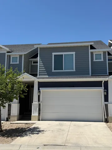 Contemporary townhome featuring a two-car garage, dark siding, and white trim