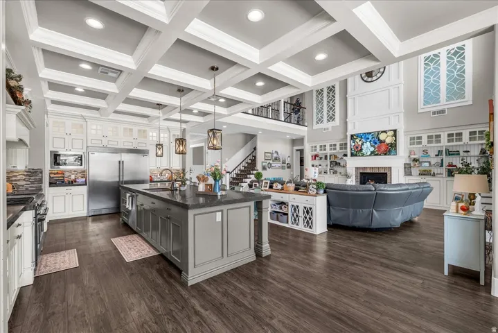 Open-concept living area featuring dark wood-finish flooring and a coffered ceiling