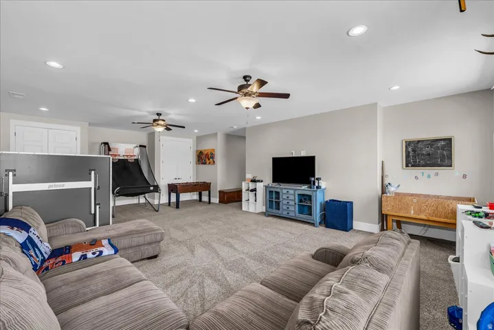 Spacious room with plush carpeting, recessed lighting, ceiling fans, and neutral wall tones