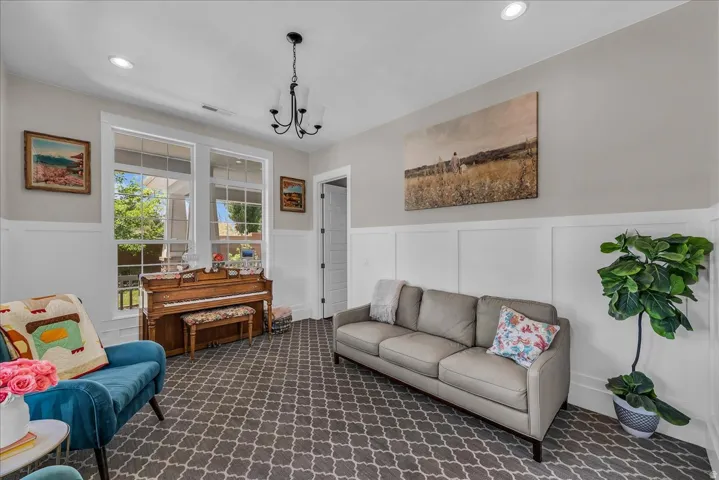 Room featuring patterned carpeting, wainscoting, recessed lighting, and a multi-pane window