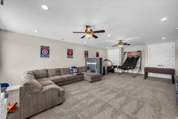 Spacious room featuring neutral carpeting, recessed lighting, and multiple ceiling fans