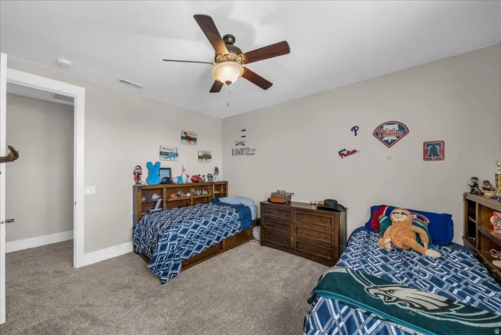 Carpeted room with a ceiling fan light fixture