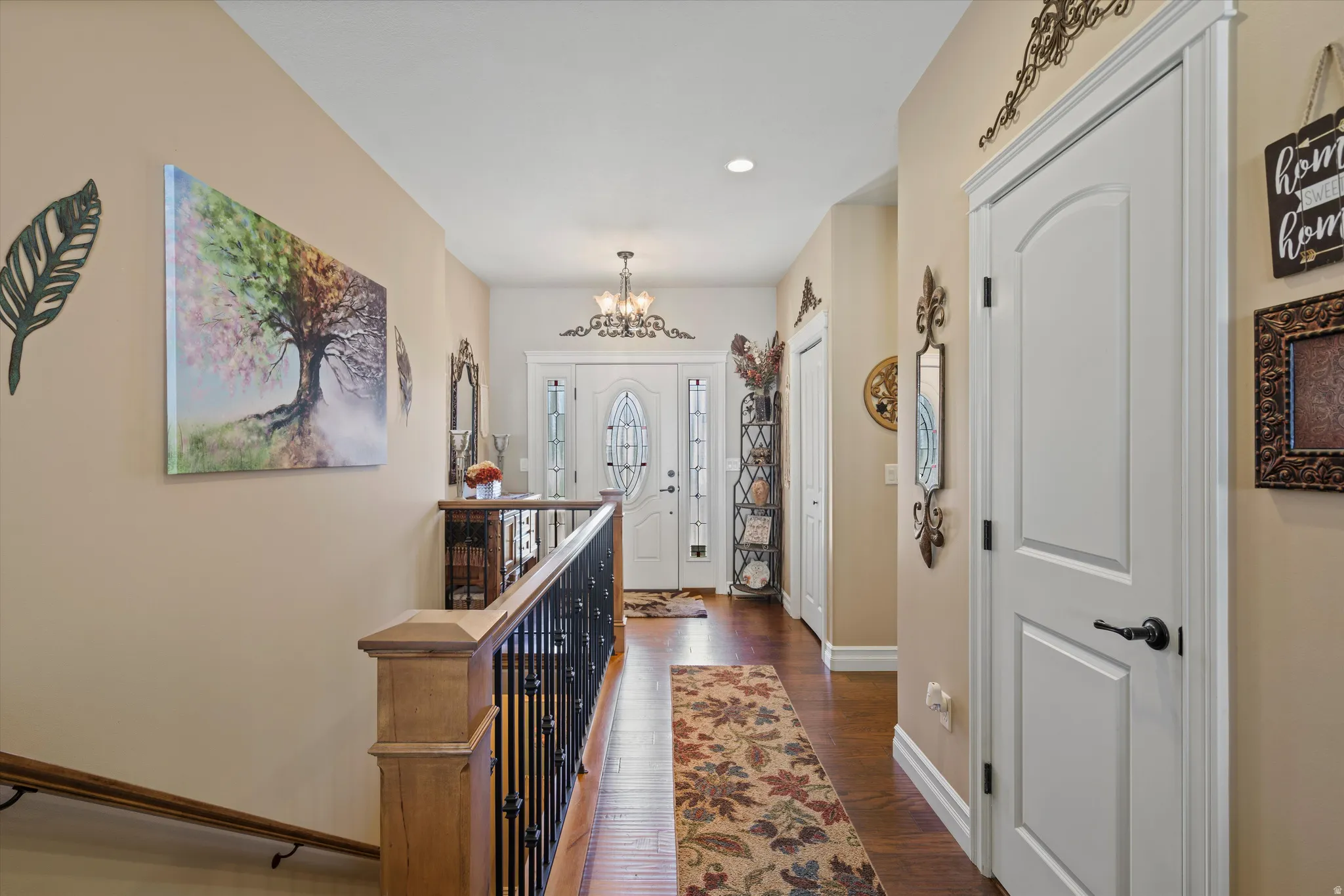 Inviting entryway featuring a white paneled front door with decorative glass, flanked by coordinating sidelights and a transom window