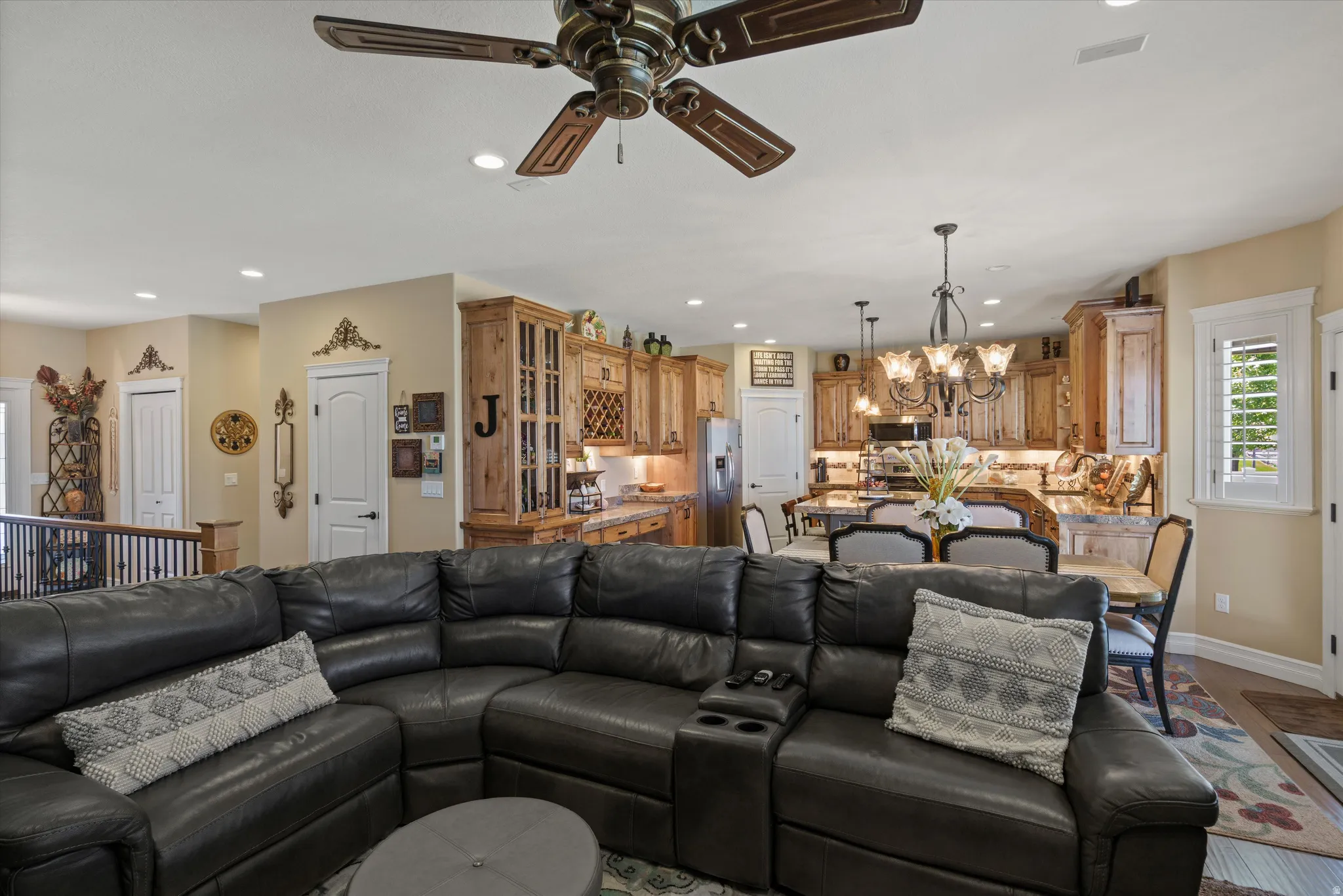 Expansive open-concept living area featuring a decorative ceiling fan, recessed lighting, and light-toned walls