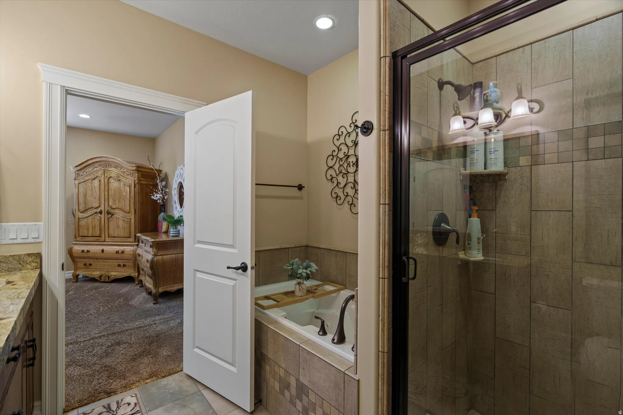 Full-size walk-in shower with glass enclosure, tiled walls, and three-bulb vanity lighting