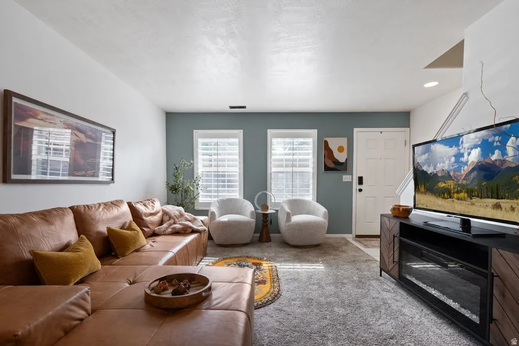 Living area featuring a textured ceiling, recessed lighting, and a front entry door with a smart lock