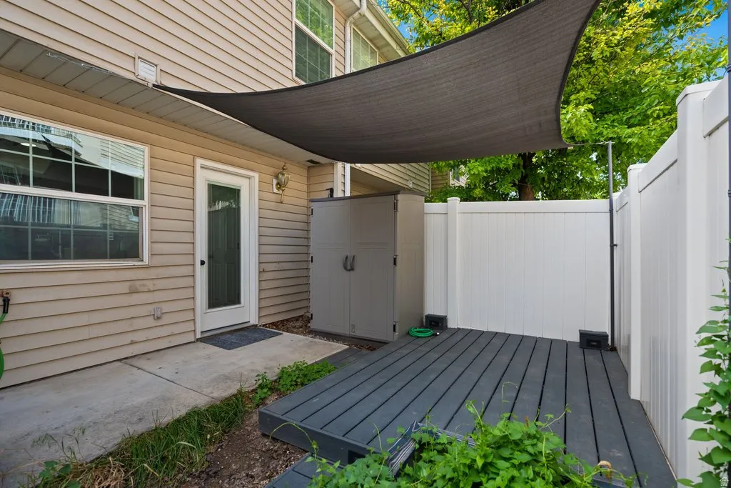 Private outdoor patio featuring dark composite decking and a sun shade