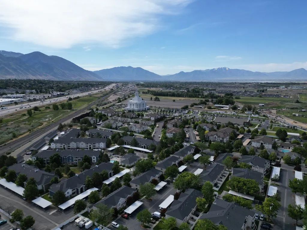 Aerial perspective showcasing a residential community with multi-story buildings, dark pitched roofs, and covered parking structures