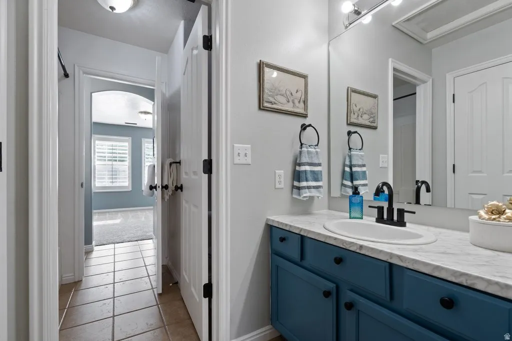 Bathroom vanity with a white countertop, oval sink, and matte black faucet