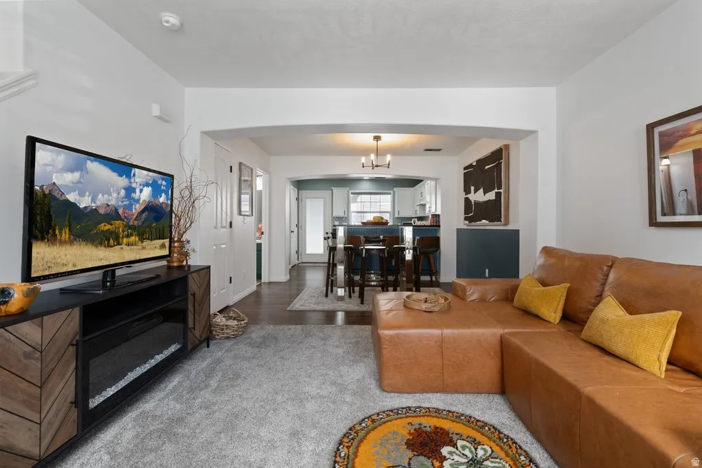 Living area with light gray carpeting and a decorative wood-finish media console