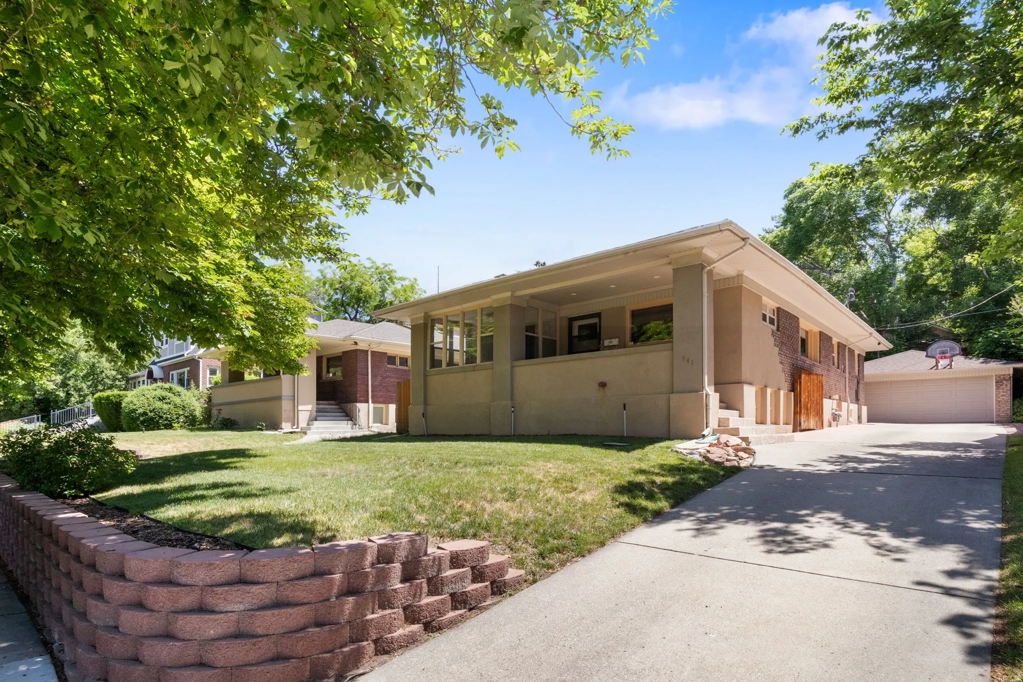 Craftsman-style residence featuring a covered front porch with substantial columns, a concrete driveway, and a detached two-car garage