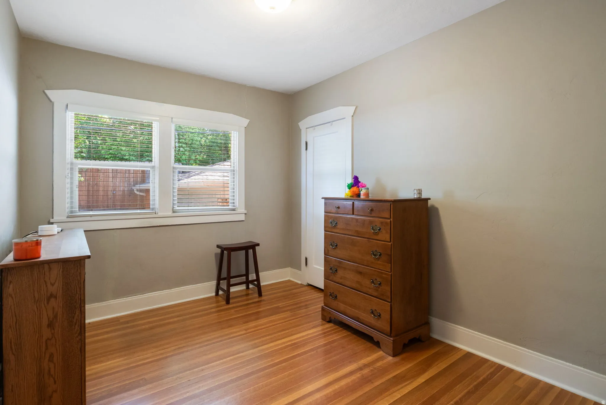 Bright room featuring wood-finish flooring and a double window with white trim