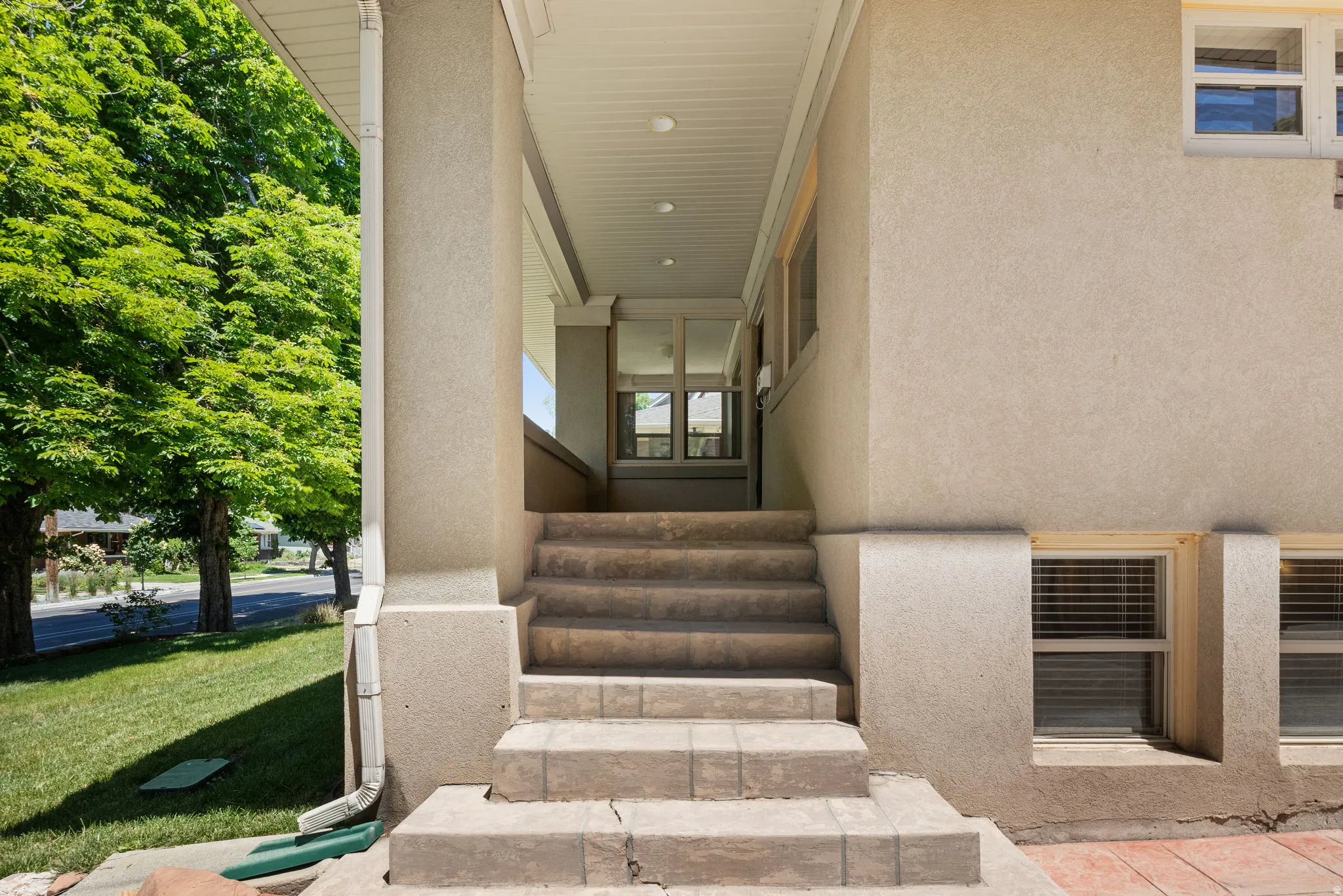 Stucco exterior with a covered porch entry
