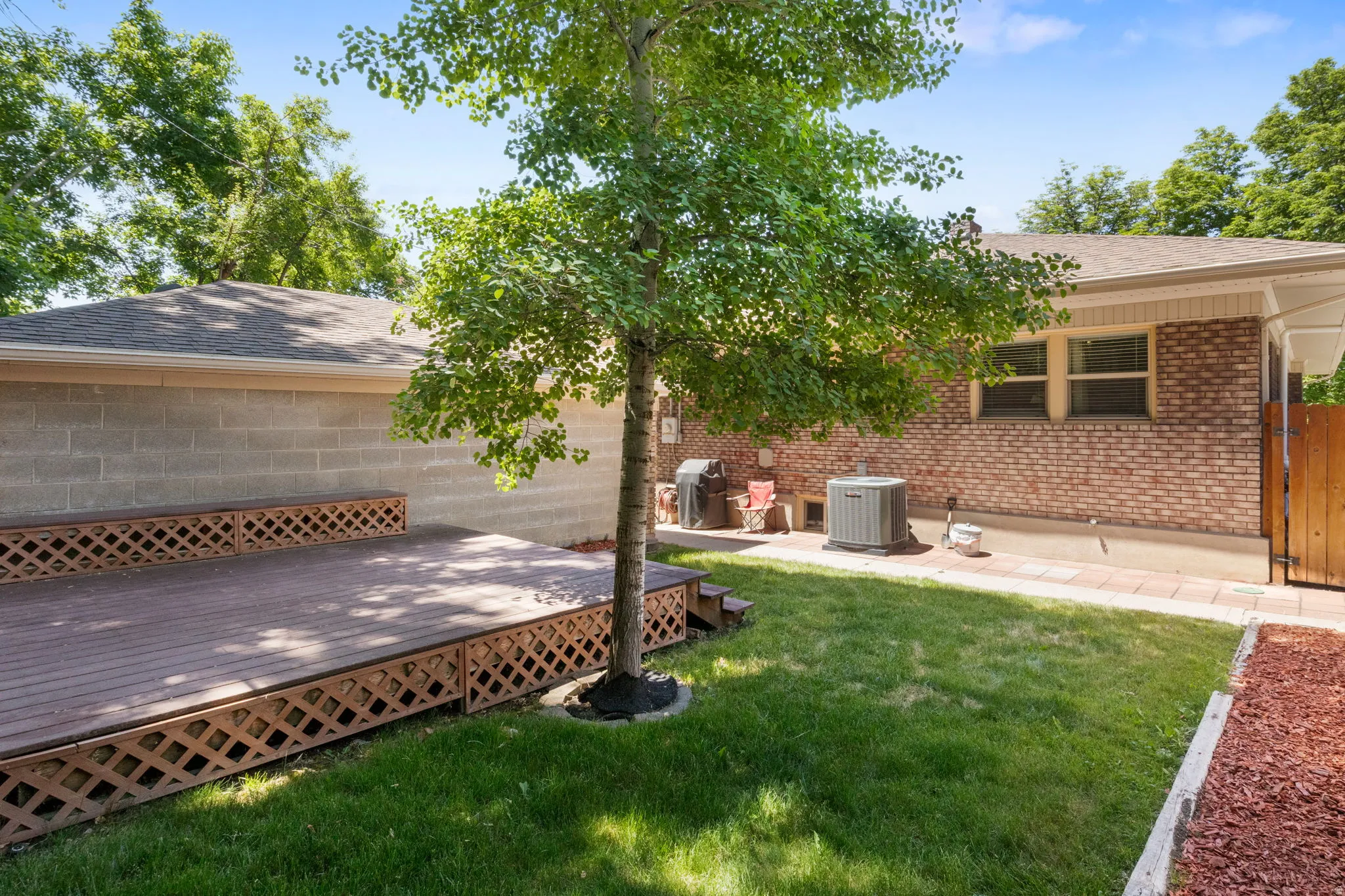 Expansive outdoor deck with lattice skirting and integrated step