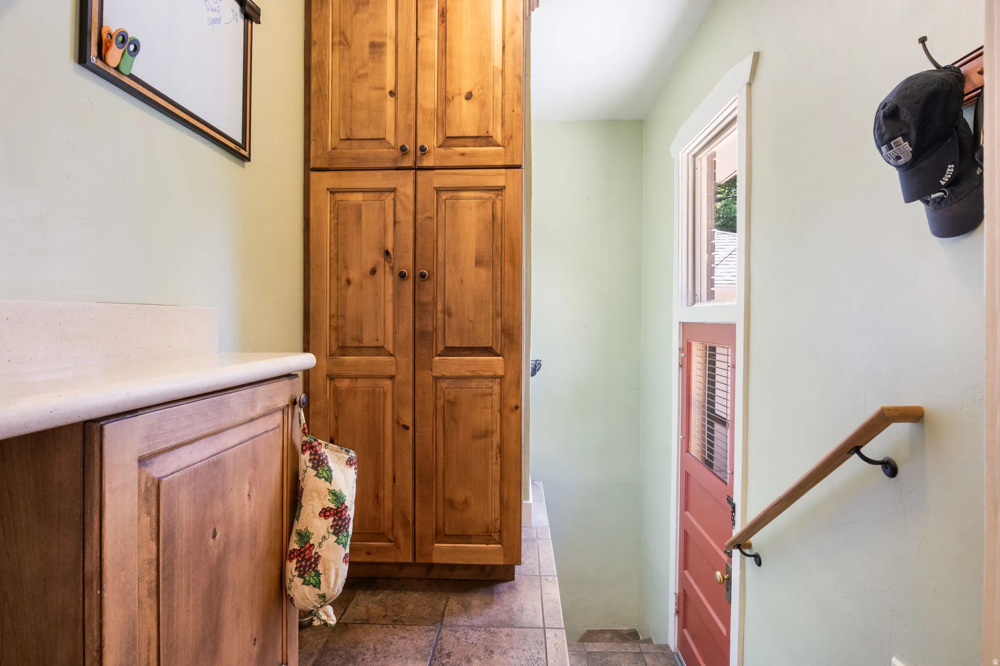 Wood-finish cabinetry and tall storage units complement the light-toned walls