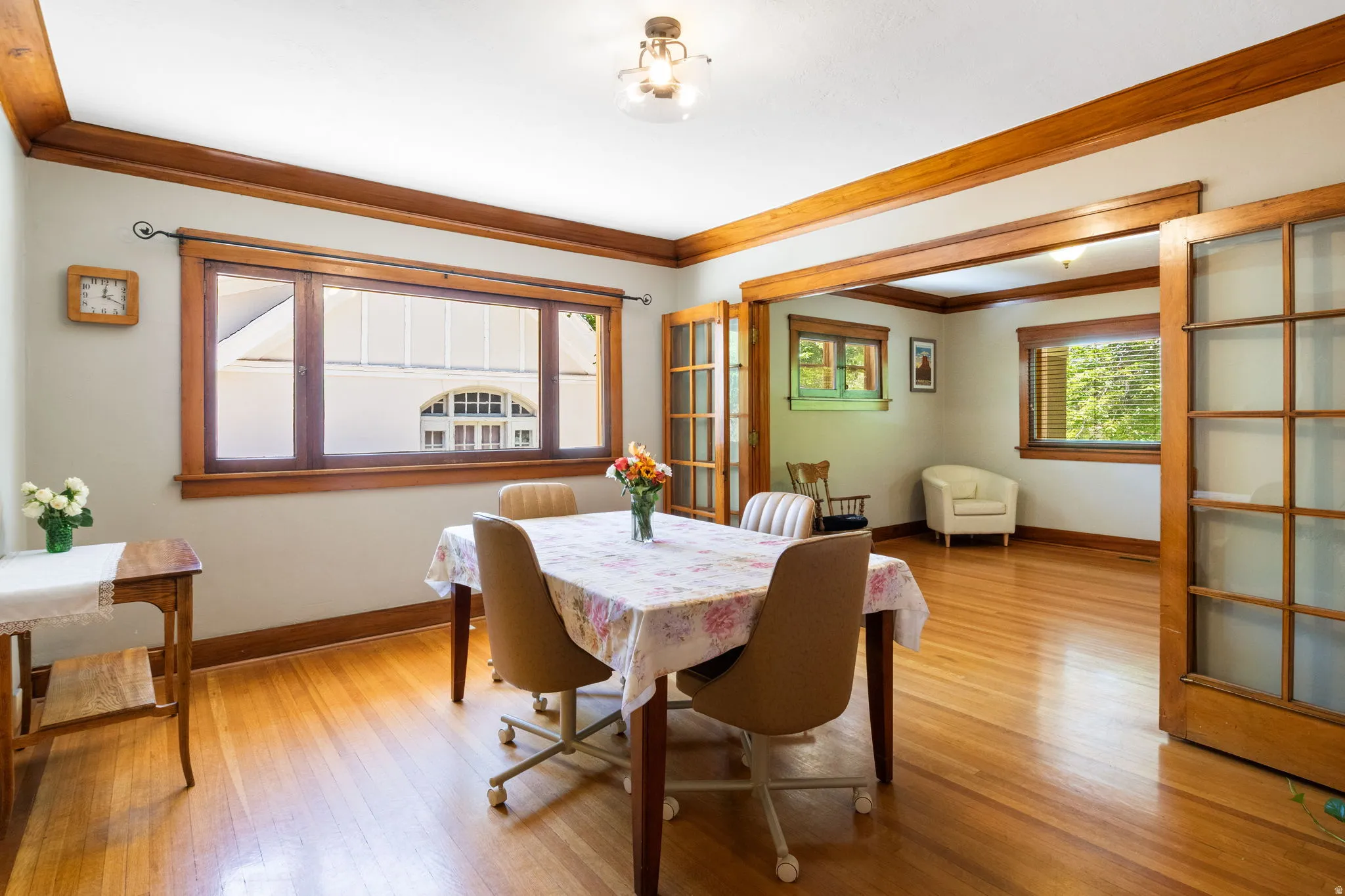Spacious room featuring wood-finish flooring, wood trim, and a prominent window framing an architectural facade