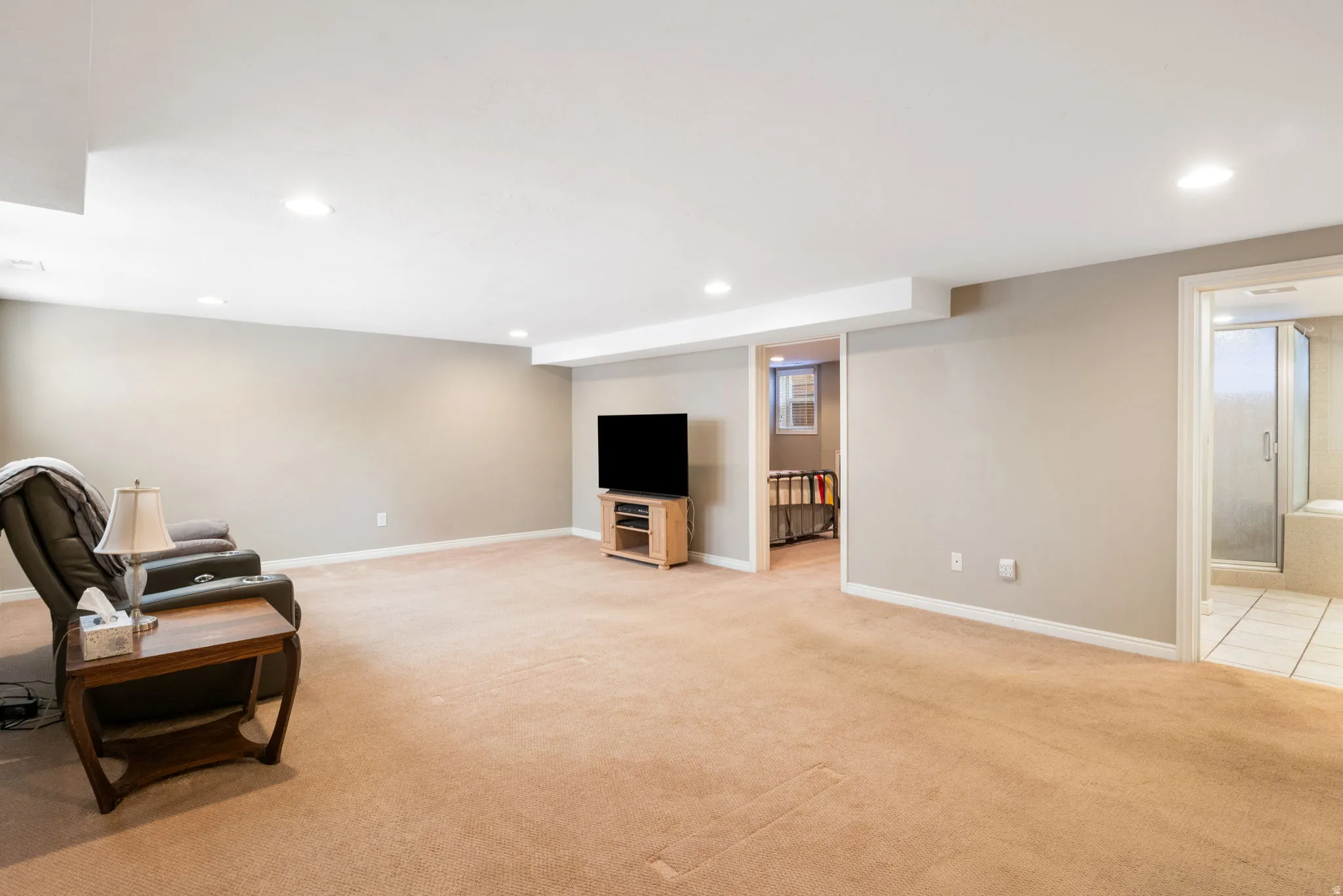 Spacious finished lower level with recessed lighting, neutral carpeting, and light gray walls