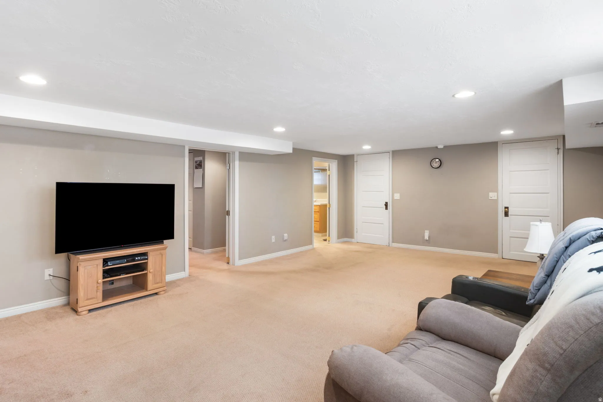 Spacious recreation room featuring recessed lighting, neutral wall paint, and light-toned carpeting