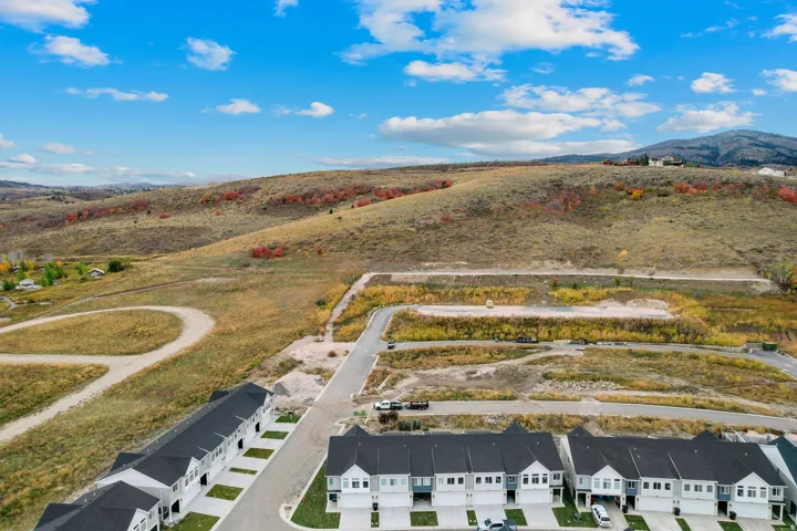 Development featuring newly constructed townhomes with dark roofing and light-colored siding