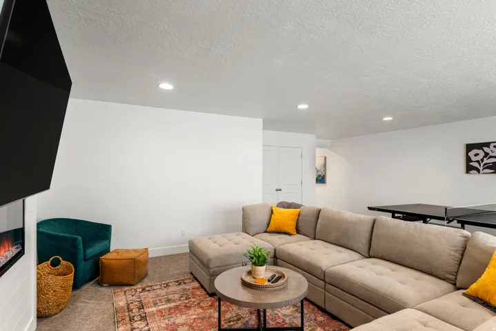 Spacious recreation area featuring a built-in fireplace, recessed lighting, and neutral wall tones