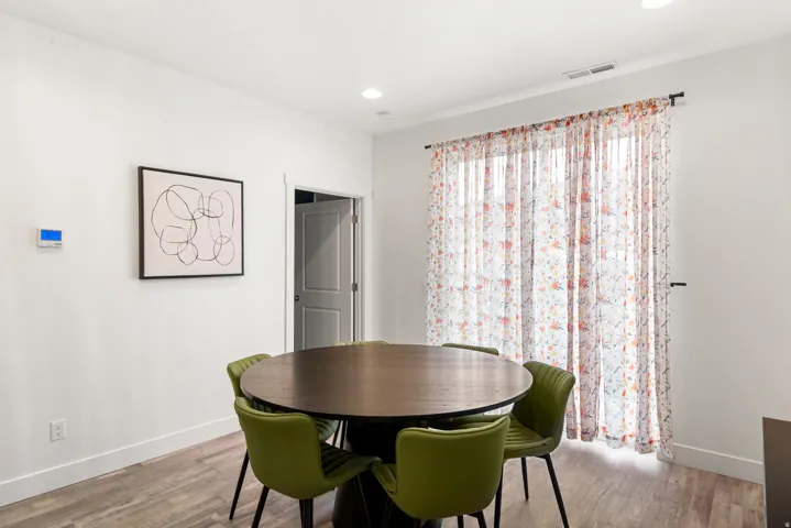 Bright interior space with wood-finish flooring, white walls, and recessed lighting