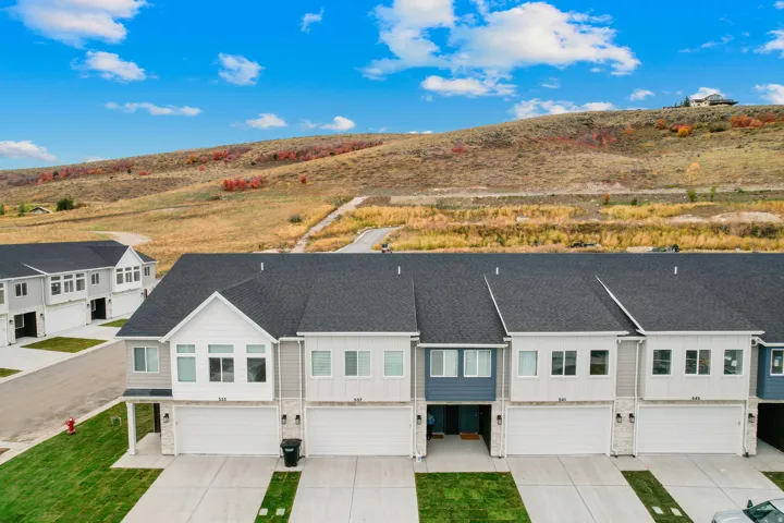Modern townhome development featuring a neutral color palette, dark shingle roofs, and individual garages