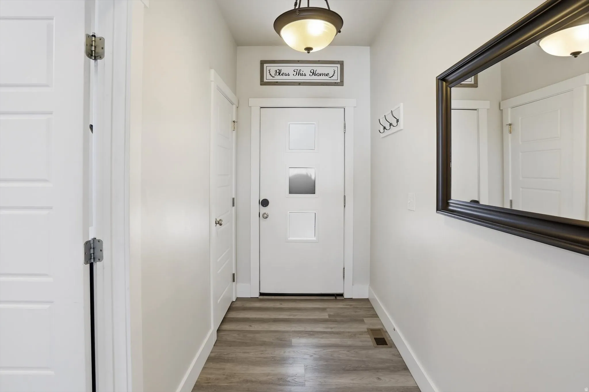 Entryway featuring a contemporary door with frosted glass inserts, wood-finish flooring, and white baseboards