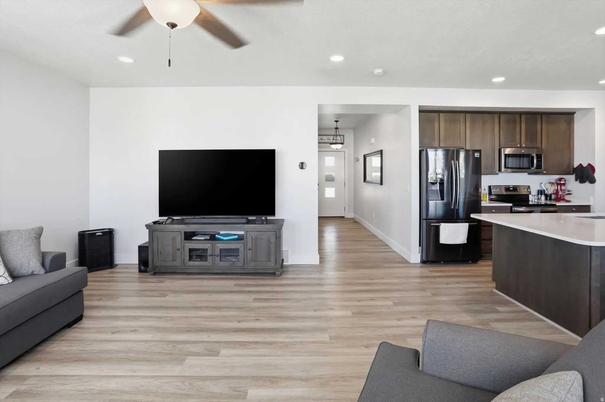 Open concept living area featuring wood-finish flooring, recessed lighting, and a ceiling fan
