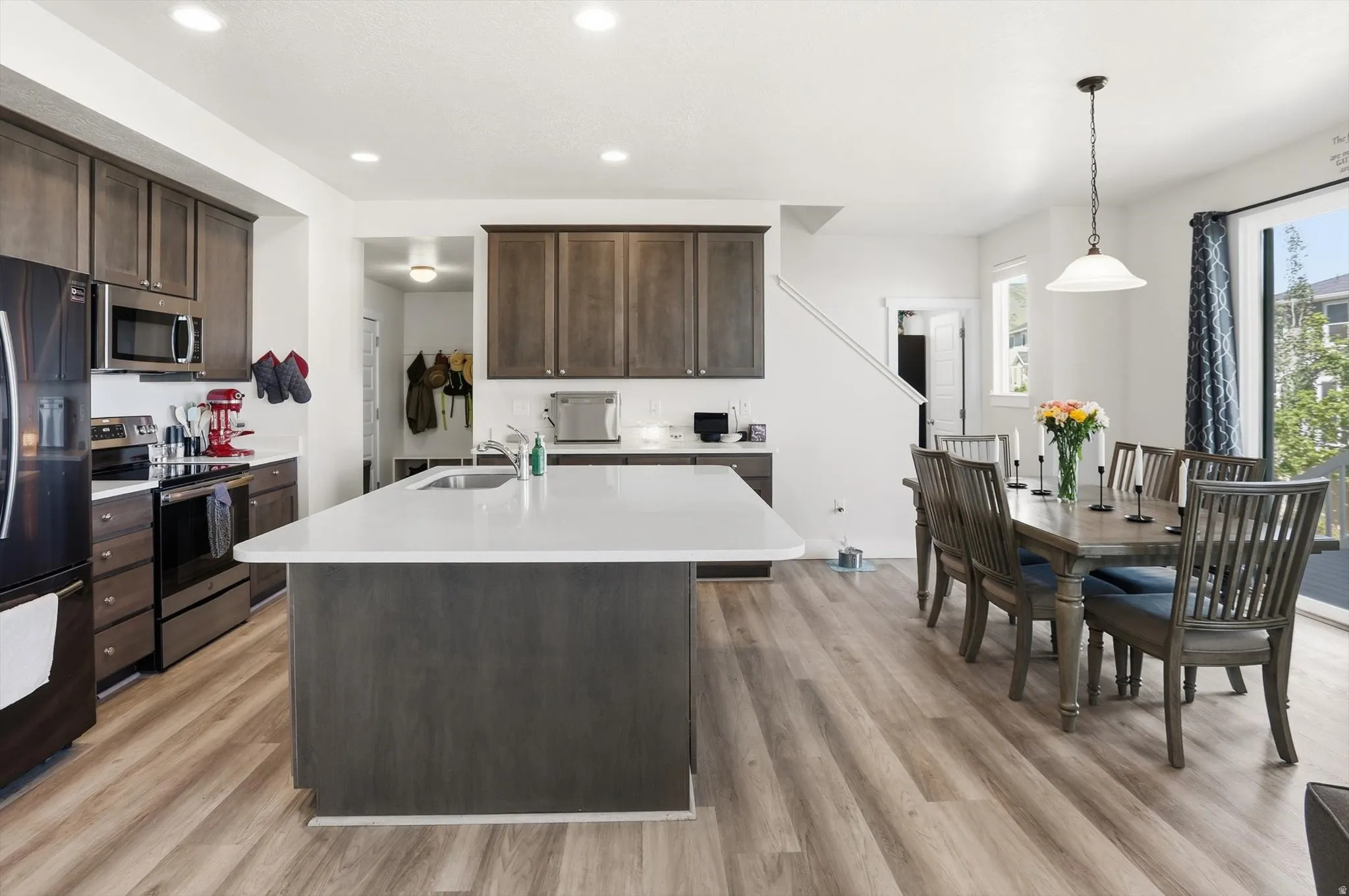 Open-concept kitchen and dining area featuring wood-finish flooring