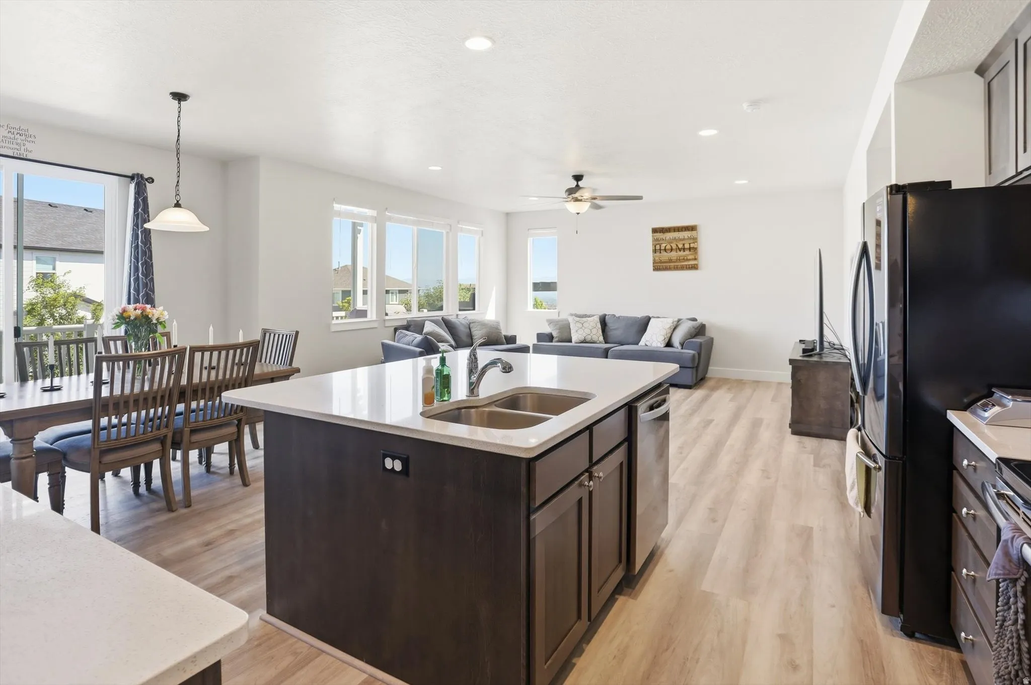 Open-concept living area featuring light wood-finish flooring, recessed lighting, and a contemporary ceiling fan
