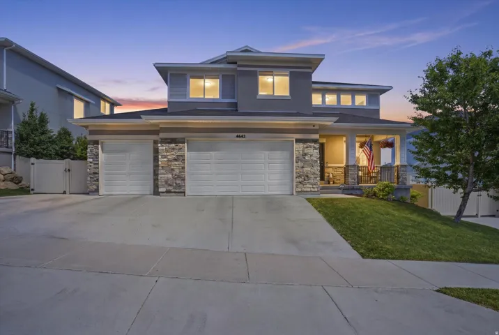 Two-story residence featuring a covered front porch with stone pillar accents