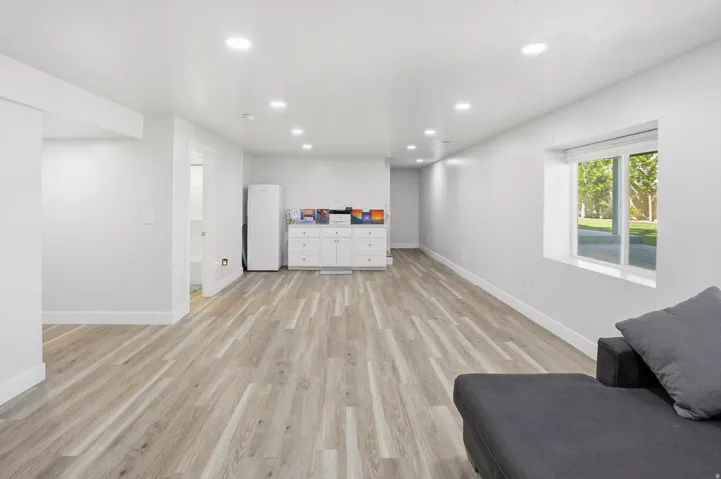 Spacious room featuring wood-finish flooring, recessed lighting, and a window with exterior views